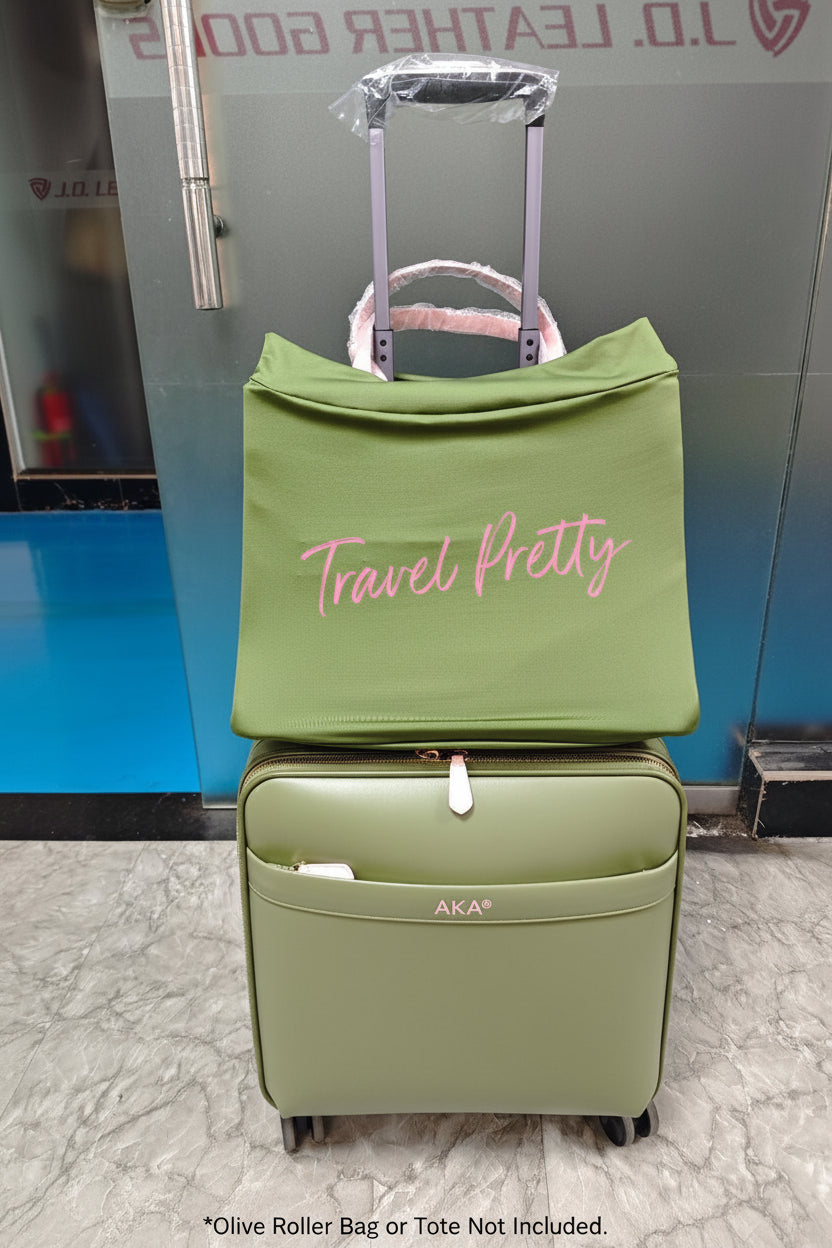 Green suitcase with a green cover labeled 'Travel Pretty' on a marble floor.